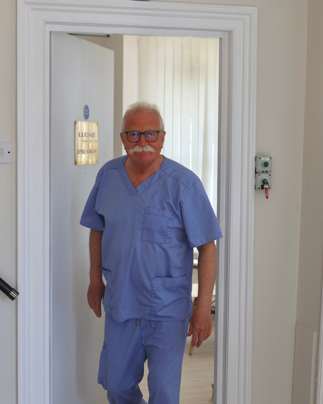 Dr Ken Aylward at the door of his surgery, beside his brass nameplate.